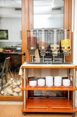 a shelf with bowls and containers of food in a kitchen at Hotel Niky in Sofia