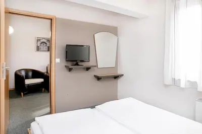 a bedroom with a mirror and a bed and a chair at Hotel Niky in Sofia
