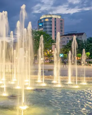 a fountain in a city with a building in the background at Rosslyn Central Park Hotel Sofia in Sofia