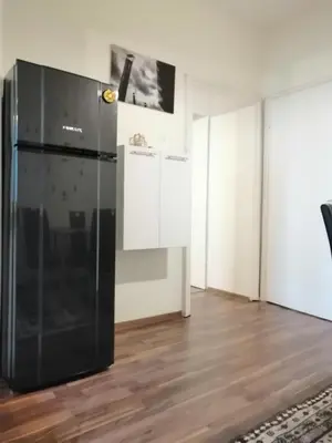 a black refrigerator in a room with wooden floors at Central Academic Apartment Sofia in Sofia