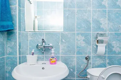 a blue tiled bathroom with a sink and a mirror at Central Academic Apartment Sofia in Sofia