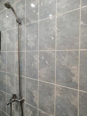 a shower with marble tile walls and a shower head at Central Academic Apartment Sofia in Sofia