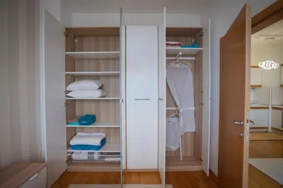a walk in closet with a glass door and towels at Michelle Apartment in Sofia