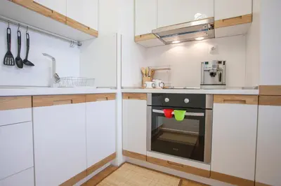a kitchen with white cabinets and a black oven at Michelle Apartment in Sofia
