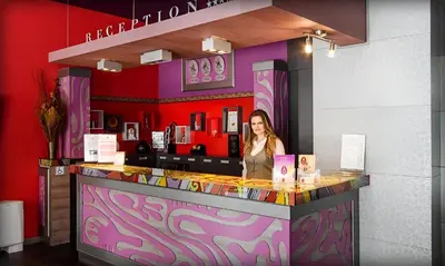 a woman standing at a bar in a restaurant at Alliance Hotel in Plovdiv