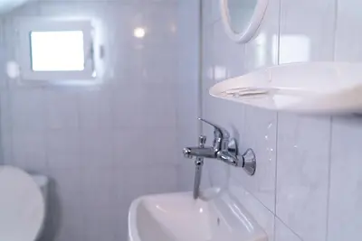 a white bathroom with a sink and a toilet at My Guest Rooms in Plovdiv