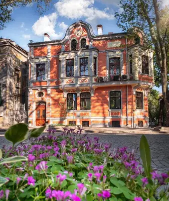 an old building with purple flowers in front of it at My Guest Rooms in Plovdiv