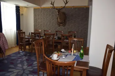 a dining room with tables and chairs and a deer head on the wall at The Lodge Hotel in Borovets