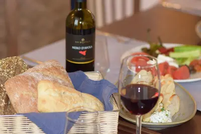 a table with a basket of bread and a glass of wine at The Lodge Hotel in Borovets