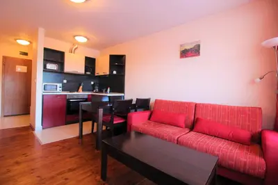 a living room with a red couch and a table at Mountview Lodge Apartments in Bansko