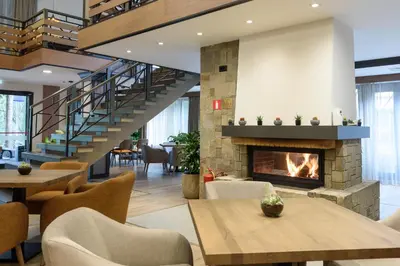 a lobby with a fireplace and tables and chairs at Lion Hotel Borovets in Borovets
