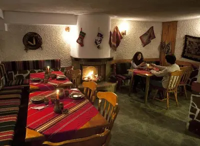 two people sitting at a table in a restaurant at Aneli Hotel in Bansko