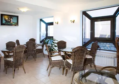 a dining room with tables and chairs and windows at Aneli Hotel in Bansko