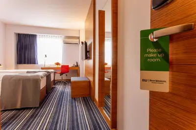 a hotel room with a bed and a sign that says please make up room at Best Western Terminus Hotel in Sofia
