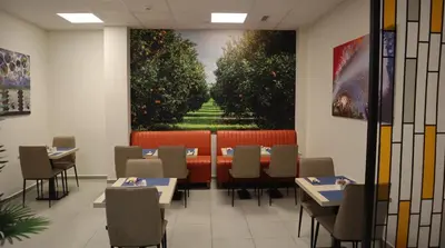 a restaurant with tables and chairs and a painting on the wall at Best Western Terminus Hotel in Sofia