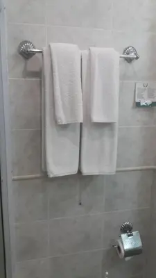 a bathroom with white towels hanging from a shower at Hotel Via Trayana in Beli Osŭm