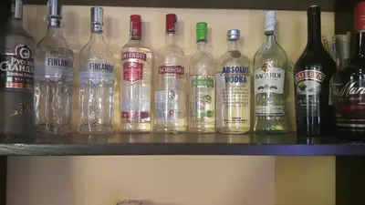 a bunch of bottles of alcohol sitting on a shelf at Hotel Via Trayana in Beli Osŭm