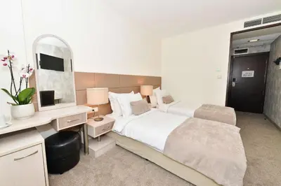a bedroom with a bed and a desk and a mirror at Art Plaza Hotel in Sofia