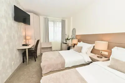 a hotel room with two beds and a desk at Art Plaza Hotel in Sofia