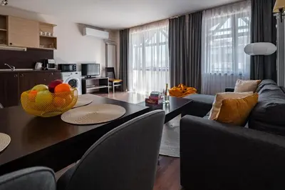 a living room with a table with a bowl of fruit on it at Apart Hotel Dream in Bansko