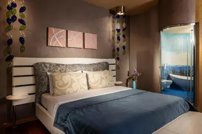 a bedroom with a bed and a tub in a bathroom at Les Fleurs Boutique Hotel in Sofia