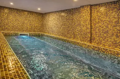 a large swimming pool in a bathroom with tiles at MPM Hotel Guinness in Bansko
