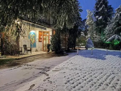 a snow covered street in front of a building at Park Hotel Amfora -Free Parking in Sofia