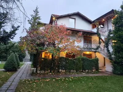 a white house with a tree in front of it at Park Hotel Amfora -Free Parking in Sofia