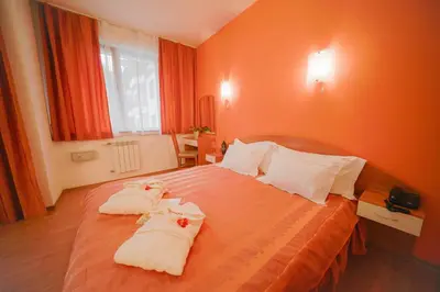 a hotel room with a bed with towels on it at Apart Hotel Flora Residence Daisy in Borovets