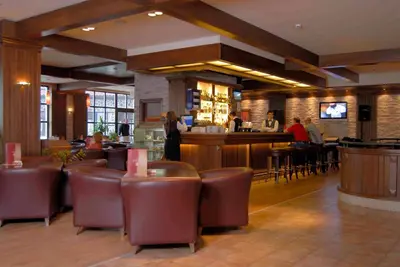a restaurant with a bar and people sitting at tables at Lion Bansko Hotel in Bansko