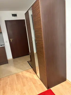 a hallway with two brown doors and a red rug at Mountain Paradise 2, One bedroom apartment in Bansko