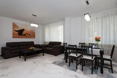 a living room with a couch and a table and chairs at Grand Vitosha Apartments in Sofia