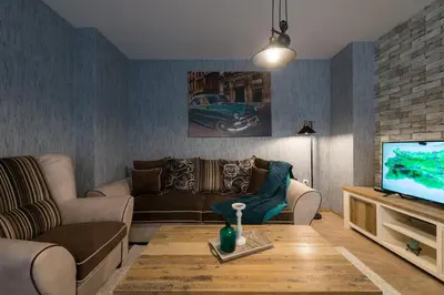 a living room with a couch and a tv at Grand Vitosha Apartments in Sofia