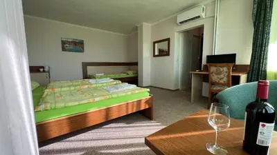 a bedroom with a bed and a table with a bottle of wine at Hotel Gorna Banya in Sofia