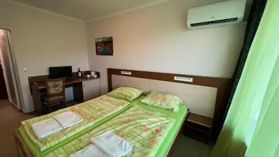 a hotel room with two beds and a desk at Hotel Gorna Banya in Sofia