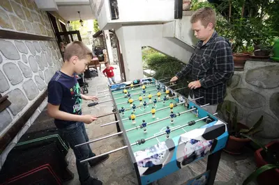 two young boys playing a game of billiard at Family Hotel Bansko Sofia in Sofia