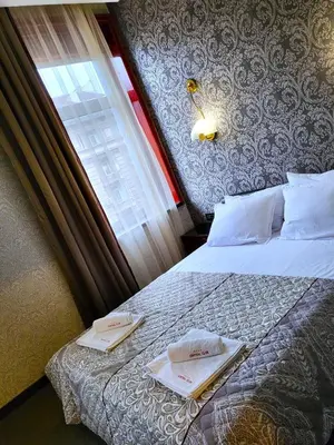 a bedroom with a bed with two towels on it at Hotel Central Club Sofia in Sofia