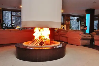 a fire pit in the middle of a living room at Gardenia Park Hotel in Bansko