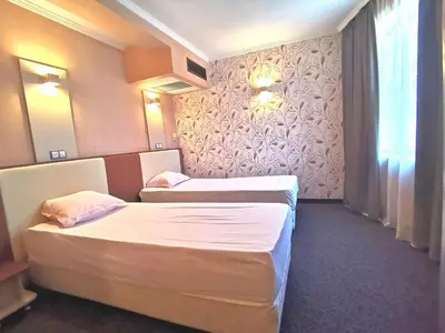 a hotel room with two beds and a window at Elate Plaza Hotel in Sofia
