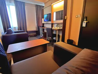 a hotel room with a couch and a table at Elate Plaza Hotel in Sofia