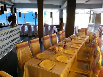 a long table in a restaurant with yellow tables and chairs at Elate Plaza Hotel in Sofia