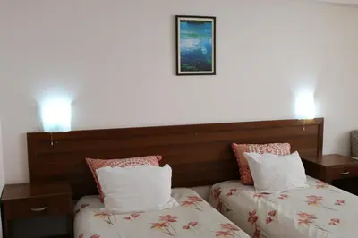 a hotel room with two beds and a picture on the wall at Kralev Dvor Hotel in Bansko