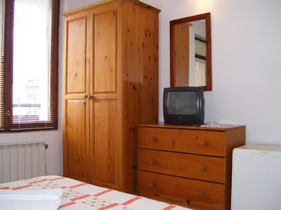 a bedroom with a dresser and a tv on a dresser at Rahoff hotel in Bansko