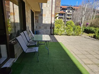 a patio with a table and chairs on a balcony at TERRA COMPLEX D4 - Private apartment - Golf, Skiing & SPA in Bansko