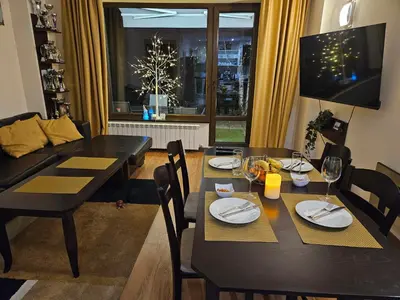 a dining room with a table and chairs and a couch at TERRA COMPLEX D4 - Private apartment - Golf, Skiing & SPA in Bansko