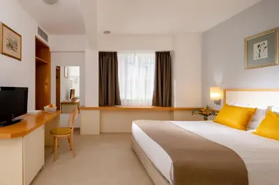 a hotel room with a large bed and a desk at Arte Sofia Hotel in Sofia