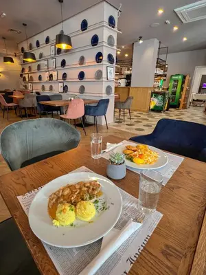 two plates of food on a wooden table at Hotel Rila in Dupnitsa