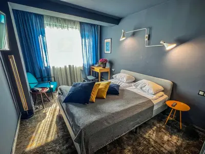 a bedroom with a bed with pillows on it at Hotel Rila in Dupnitsa