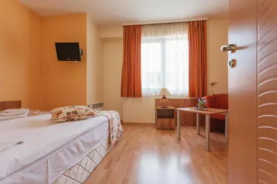 a hotel room with a bed and a table and a window at Bright House in Plovdiv