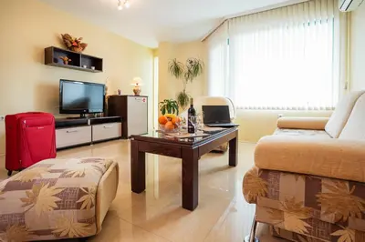 a living room with a couch a table and a tv at Bright House in Plovdiv